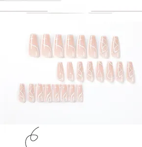 Detail of long coffin press-on nails with white butterfly and starburst patterns