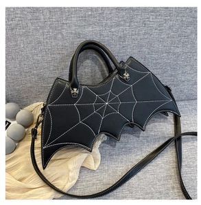 Detail of bat-shaped gothic crossbody bag featuring silver cross hardware and spiderweb pattern