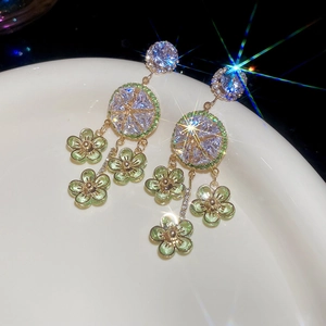 Macro view of light green floral drop earrings with sparkling zircon tassels