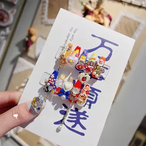 Detail of 3D Japanese press-on nails with lucky cat, tiger motifs and metal chain accents