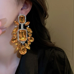 Close-up of vintage amber teardrop earrings with faceted crystals on a model