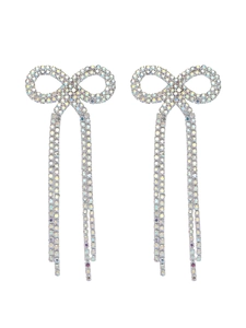 Detailed view of silver bow earrings featuring shimmering rhinestones and long tassels