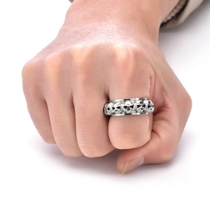 Détail d'une bague tête de mort rotative en acier inoxydable avec relief punk porté à la main