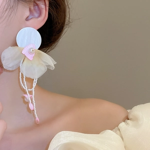 Detail of floral fabric petals and pearl tassels on elegant long drop earrings