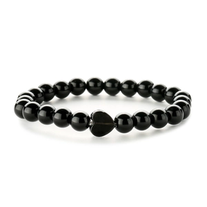 Polished black gemstone beaded bracelet with heart-shaped pendant on white background