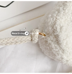 Detail of plush white rabbit coin purse showing gold metal D-ring and woven strap