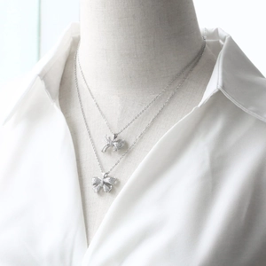 Detail of silver bow necklaces with sparkling cubic zirconia on a mannequin