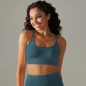 Detailed view of seamless knitted teal sports bra with cross back straps and ribbed band