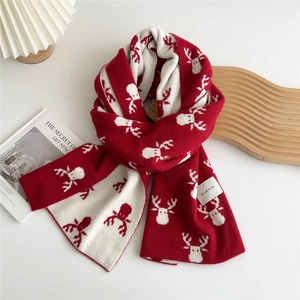 Close-up of red and beige Christmas knit scarf with deer pattern and HELLO PLAN label