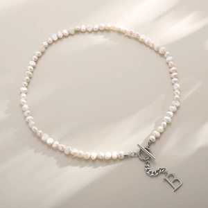 Detailed shot of freshwater pearl necklace with silver OT clasp and letter B pendant