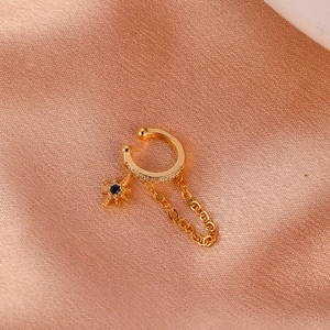 Detail von Gold-Ohrklemme mit Zirkonia, Stern-Anhänger, blauem Stein und feiner Kette