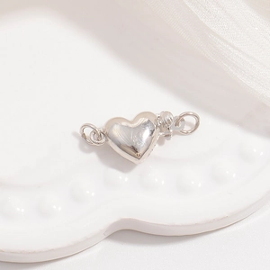 Macro shot of silver 3D heart-shaped jewelry clasp connector for necklaces and DIY pearls