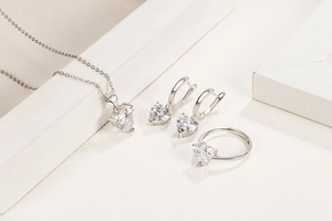 Detail shot of heart-shaped zircon necklace, earrings, and ring set in silver metal