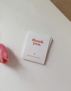 Detail showing white rectangular Thank You packaging stickers with elegant pink text