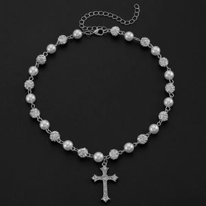 Vue macro du collier croix gothique avec perles et détails en cristal étincelants