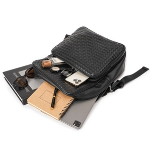 Detail view of woven leather backpack showing spacious interior for laptop and essentials