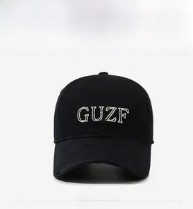 Detailed view of the sparkling rhinestone GUZF embroidery on a distressed black baseball cap