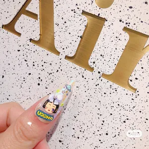 Macro view of 5D embossed nail sticker with purple 3D bow, pearl, and cartoon girl