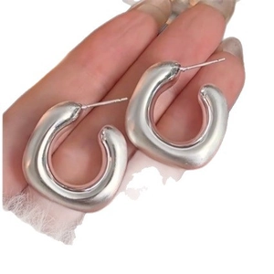 Thick silver C-shaped geometric hoop earrings with a polished metallic finish