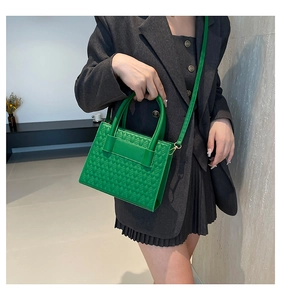 Détail du sac fourre-tout vert vif avec texture en losanges porté avec un blazer gris