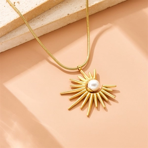 Golden sunburst necklace with pearl pendant on snake chain with elegant stone backdrop