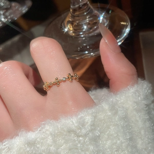 Close-up of 18k gold-plated beaded ring with a small zircon on a finger