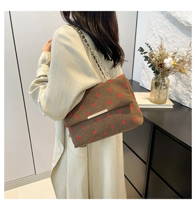 Brown corduroy shoulder bag with strawberry print and gold chain strap on model
