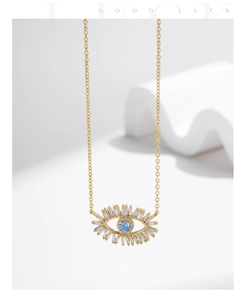 Macro shot of 18K gold evil eye necklace with blue zircon and baguette eyelashes
