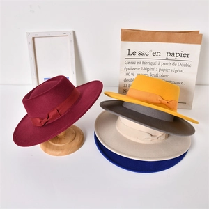Detailed arrangement of five colorful felt fedora hats with ribbon bows on a display