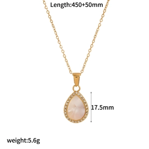 Detail shot of a golden teardrop pendant with mother of pearl and small diamonds