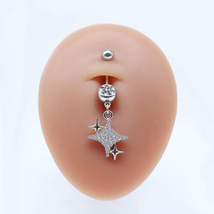 Macro view of silver belly ring with a sparkling cross star pendant and clear zircon