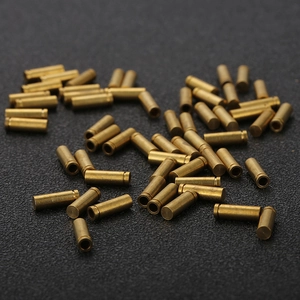 Bulk brass cylindrical metal hardware components and precision spacers on grey background