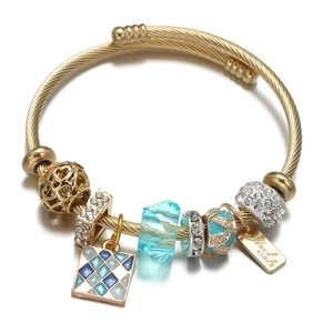 Detail of gold wire bangle with blue crystal beads and hollow heart charm decoration