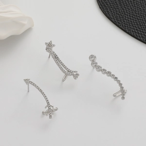 Detail view of silver ear cuffs set with sparkling white zircon in leaf and star shapes