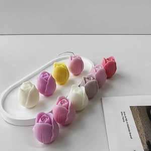 Detailed view of colorful tulip candles in a white tray for home decor and aromatherapy