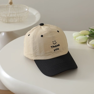 Detail view of the smile embroidery and Thank You text on the contrast baseball cap