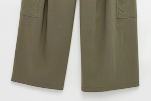 Detailed close-up of stitching and side cargo pocket on army green wide-leg work pants
