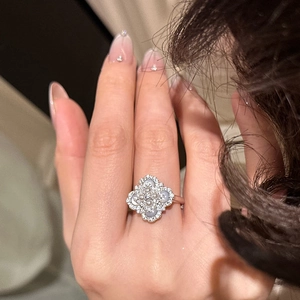 Close-up of a silver clover ring with pearls and zircon stones worn on a model hand