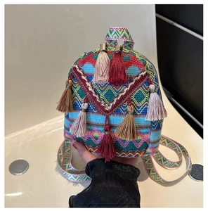 Detail of colorful woven ethnic mini backpack featuring intricate geometric patterns and tassels