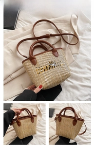 Detail of tiger embroidery on brown straw woven tote bag with faux leather handles