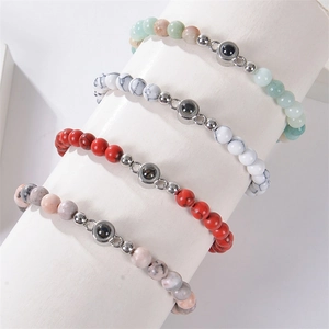 Detail view of natural stone beaded bracelets with center projection gemstone in four colors