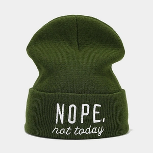 Gros plan du bonnet vert en maille avec broderie blanche 'NOPE. not today' détaillée