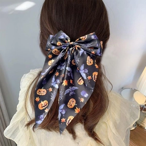 Halloween ribbon bow hair clip featuring pumpkin and spider web prints on satin