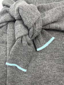 Detail of grey knit sweater showing mint green contrast trim and fine texture
