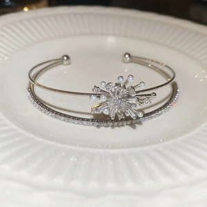 Detailed close-up of double-layer silver bangle with pearls and zircon starburst details