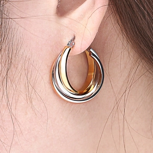 Detail shot of tricolor interlocking hoop earrings in gold, silver and rose gold finish
