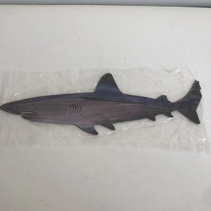 Detail of shark-shaped steel art wall decor wrapped in protective plastic packaging