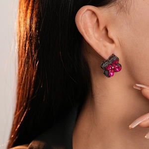 Close-up of vintage floral earrings with pink rhinestones on black metal base
