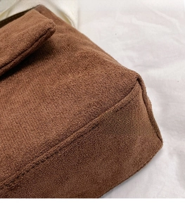 Close-up of brown matte fabric texture and reinforced stitching on a vintage bag
