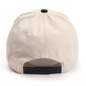 Beige baseball cap with black snapback closure and embroidery holes on a white background